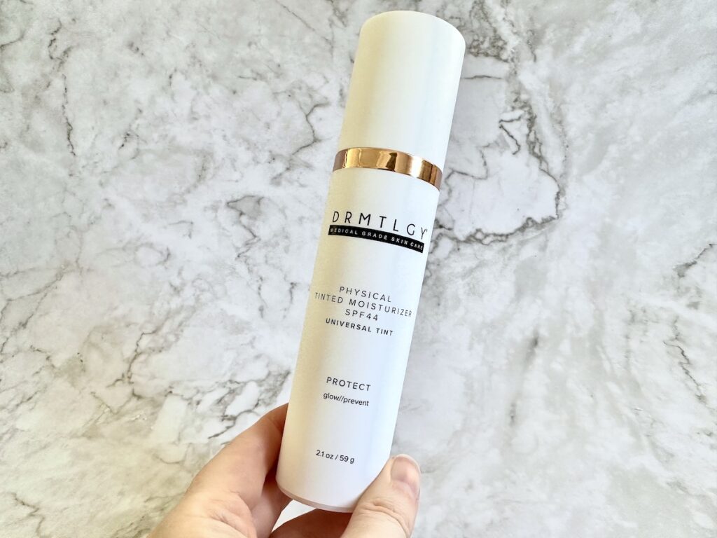 Drmtlgy Physical Universal Tinted Moisturizer SPF 44, handheld.